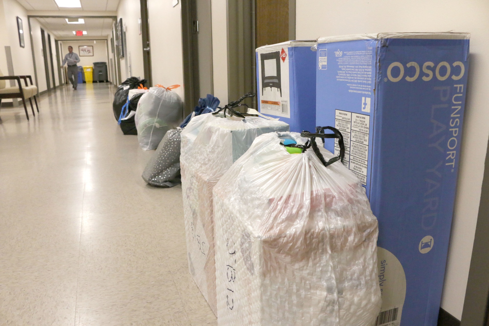 Presents dropped off for the 2018 AEDC Angel Tree program line a hallway in the Arnold Air Force Base Medical Aid Station after a storage room in the facility became filled with gifts. (U.S. Air Force photo by Bradley Hicks) (This image was altered by obscuring badges for security purposes)