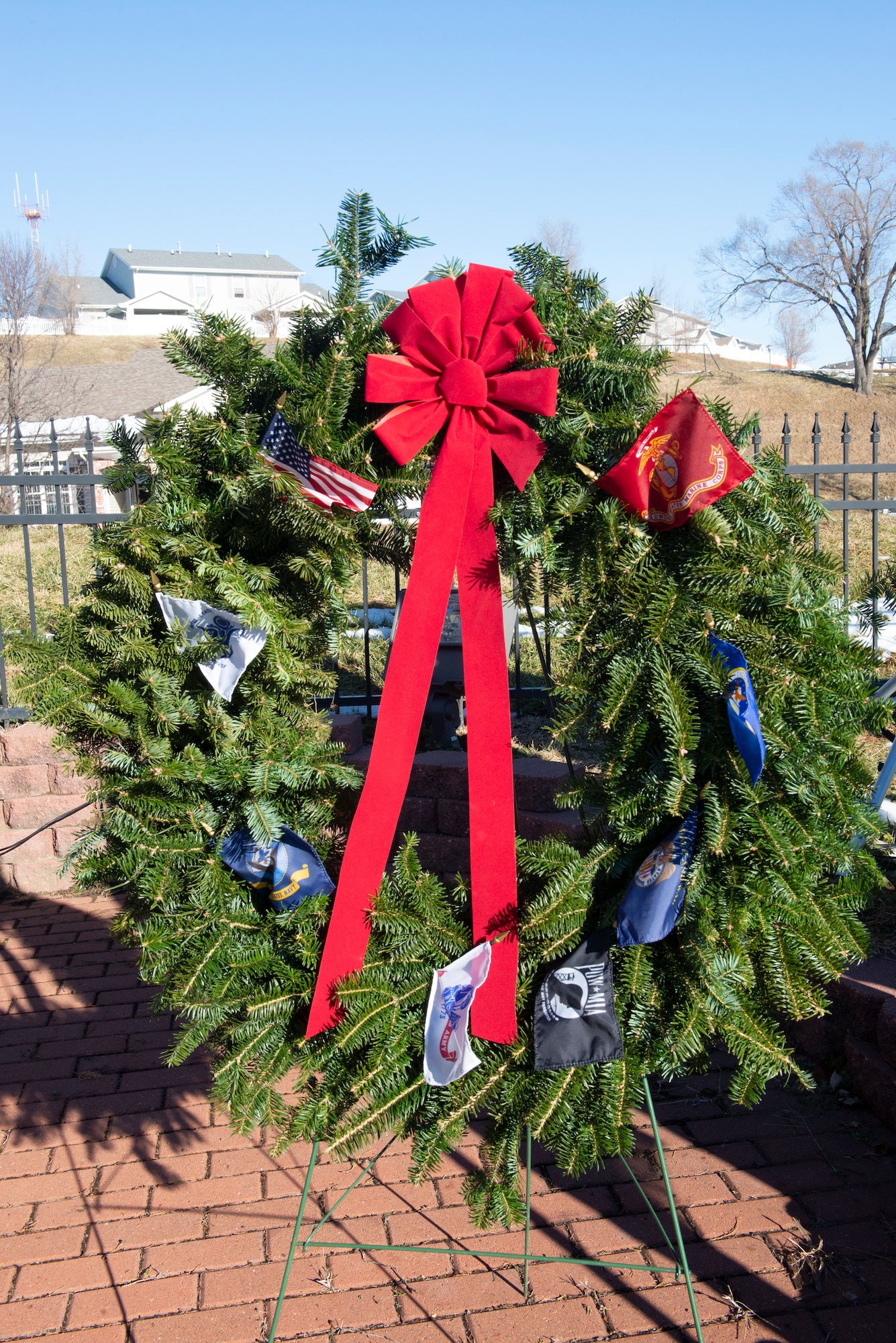 A large 3-foot wreath stands displayed at the National Wreaths Across America Ceremony Dec. 15, 2018, at the Offutt Air Force Base Cemetery, Nebraska. The wreath was decorated with a small United States Flag and flags representing U.S. Army, U.S. Air Force, U.S Navy, U.S. Marine Corp, U.S. Coast Guard, U.S. Merchant Marines, Prisoner Of War/Missing In Action flags. The cemetery was instated into the WAA, Nov. 27, 2018. The WAA is a non-profit organization that provides Christmas wreaths for over 1,200 veterans’ cemeteries in the United States and overseas. (U.S. Air Force photo L. Cunningham)