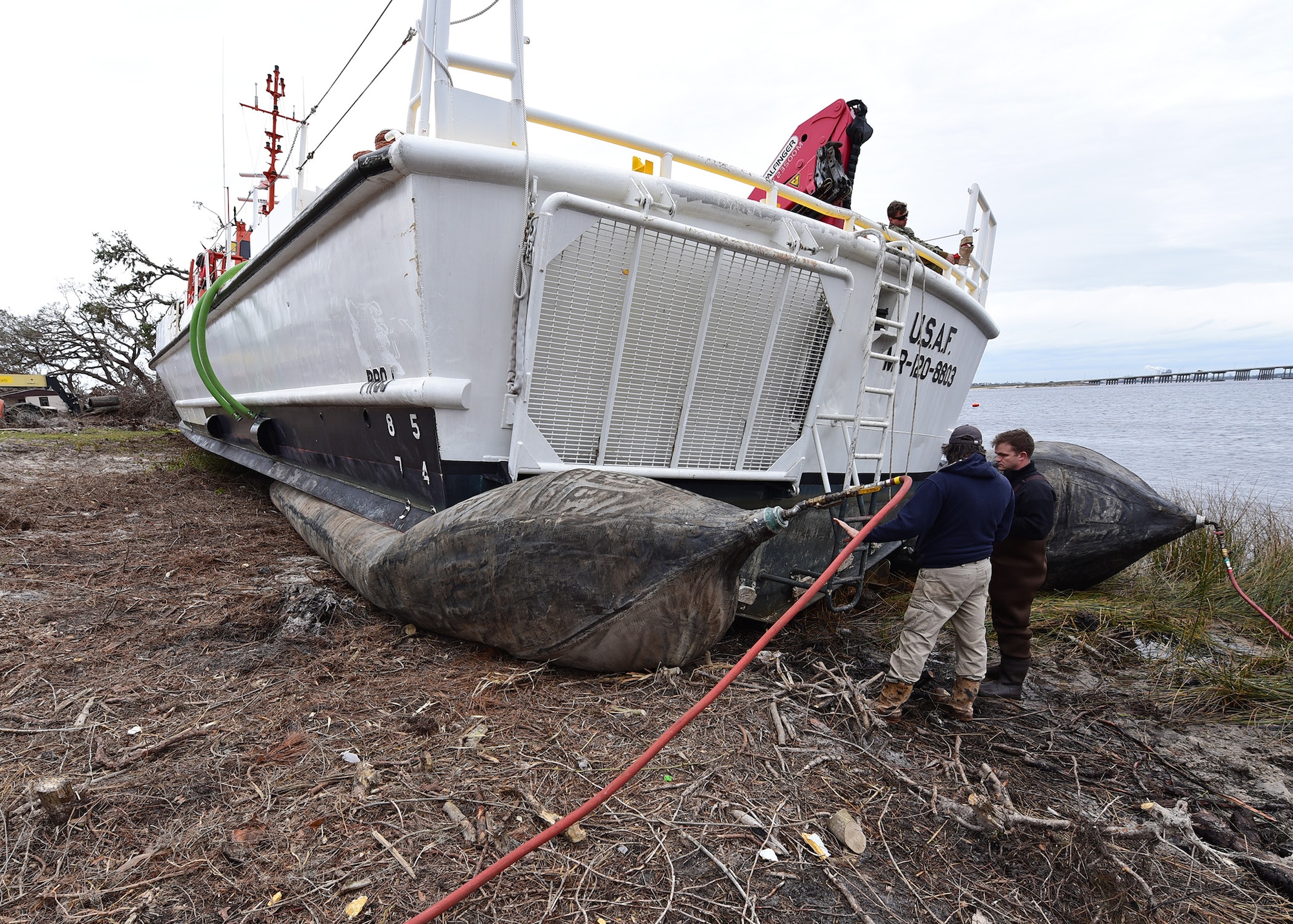 Large bladders are inflated while beneath a beached U.S. Air Force Missile Retriever Ship near Tyndall Air Force Base, Fla., Dec. 13, 2018. The vessel was beached during the strong winds of Hurricane Michael. Sailors from Mobile Diving and Salvage Unit (MDSU) 2, homeported at Joint Expeditionary Base Little Creek-Ft. Story, partnered with Tyndall personnel to return the vessel to the water. (U.S. Air Force photo by Senior Airman Isaiah J. Soliz)