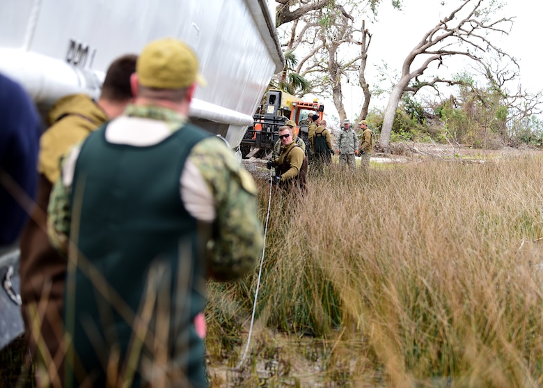 Sailors from Mobile Diving and Salvage Unit (MDSU) 2, homeported at Joint Expeditionary Base Little Creek-Ft. Story, run a steel cable the length of a beached vessel at Tyndall Air Force Base, Fla., Dec. 13, 2018. Sailors and contractors partnered with Tyndall personnel to return the beached U.S. Air Force Missile Retriever Ship to the water more than two months after Hurricane Michael pushed it ashore. (U.S. Air Force photo by Senior Airman Isaiah J. Soliz)