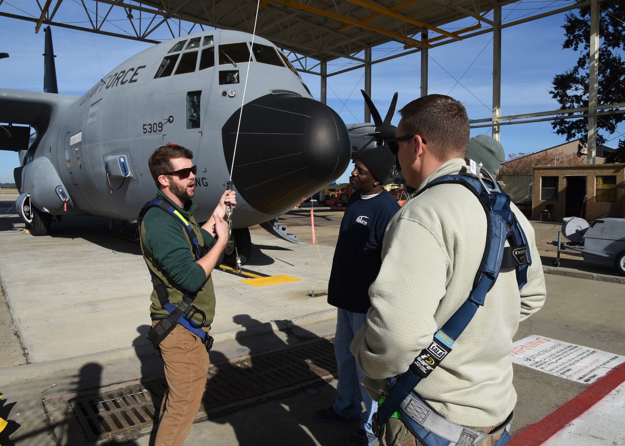 Jordan Moon, Webb Rite Safety, trains military and contract personel on the new wash rack safety harness feature. The 403rd Wing installed safety harnesses in the Wash Rack at Keesler Air Force Base Dec. 10-13, 2018. The C-130J Super Hercules aircraft are washed every 30 days and with the new safety feature contract and military personnel will be able to wash the aircraft more thoroughly as well as safely. (U.S. Air Force photo by Maj. Marnee A.C. Losurdo)