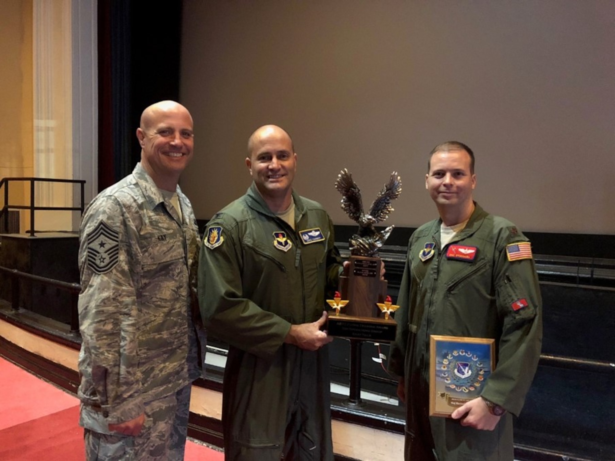 U.S. Air Force Col. Eric Carney, 97th Air Mobility Wing commander, Chief Master Sgt. Randy Kay, 97th AMW Command Chief and Maj. Eric Stoddard, 58th Airlift Squadron Commander of Standards and Evaluation, receive the Top Operations Group-Gray Tail Division Award Group during the Air Education and Training Command Flying Training Awards Ceremony Oct. 26, 2018, at Joint Base San Antonio-Randolph, Texas. The annual event recognizes the exceptional personnel dedicated to training aircrew across the 19th Air Force. (Courtesy Photo)