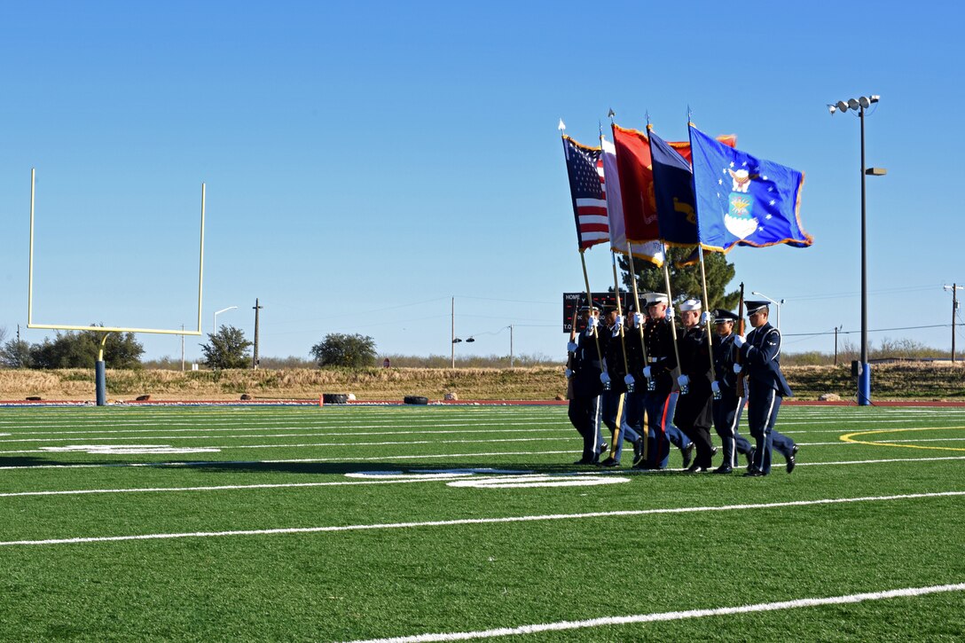 Joint Service Color Guard marches onto the field to present the colors during the Army-Navy game at the Mathis Fitness Center field on Goodfellow Air Force Base, Texas, Dec. 14, 2018. After presenting the colors, there was the playing of “retreat” and the “national anthem” followed by the coin flip to begin the game. (U.S. Air Force photo by Airman 1st Class Zachary Chapman/Released)