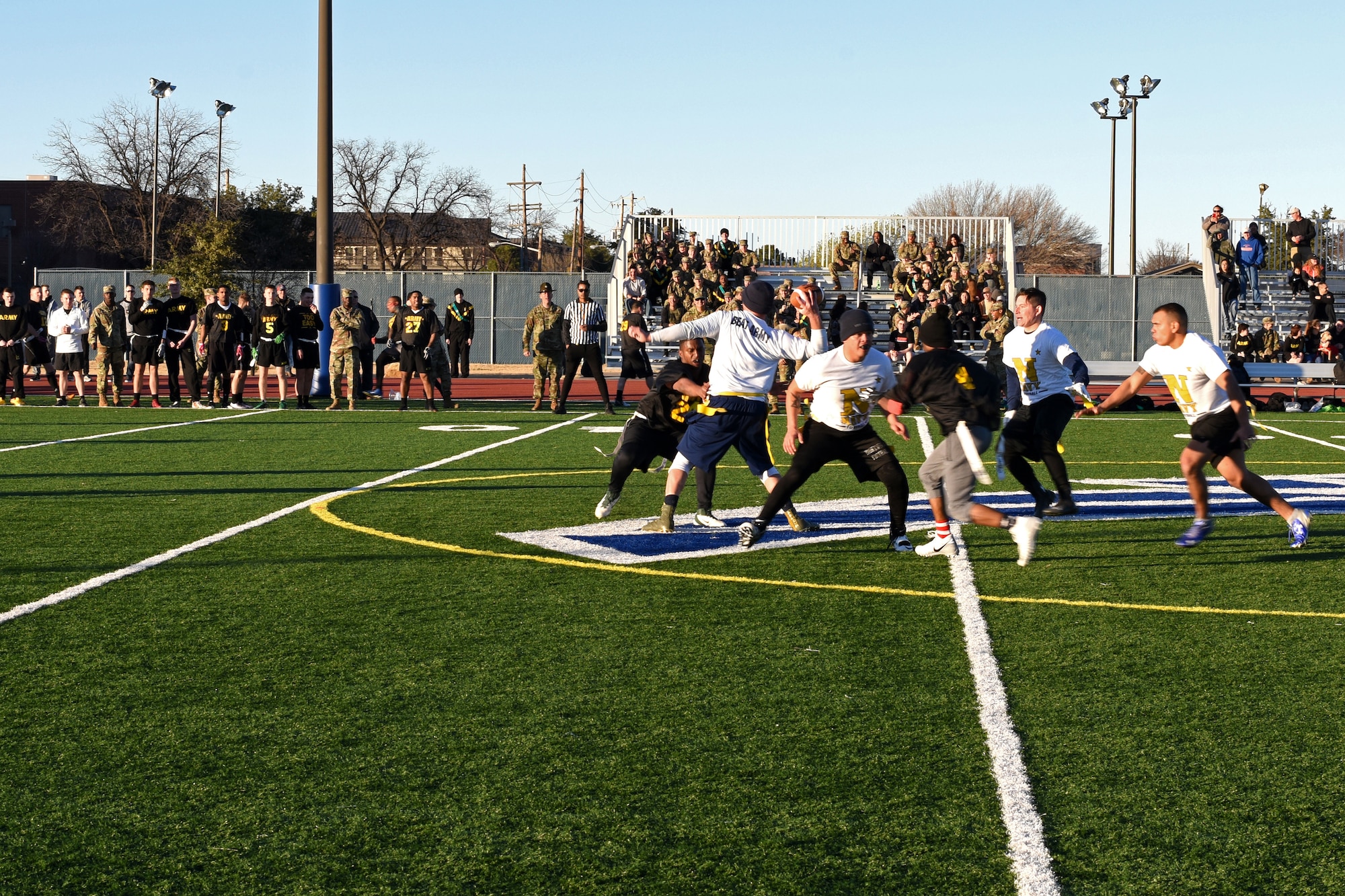 U.S. Navy Petty Officer 1st Class Cody Sykes, 312th Training Squadron fire instructor, avoids having his flag pulled, while trying to pass the ball, during the Army-Navy game at the Mathis Fitness Center field on Goodfellow Air Force Base, Texas, Dec. 14, 2018. The Army defeated the Navy with a final score of 13-7. (U.S. Air Force photo by Airman 1st Class Zachary Chapman/Released)