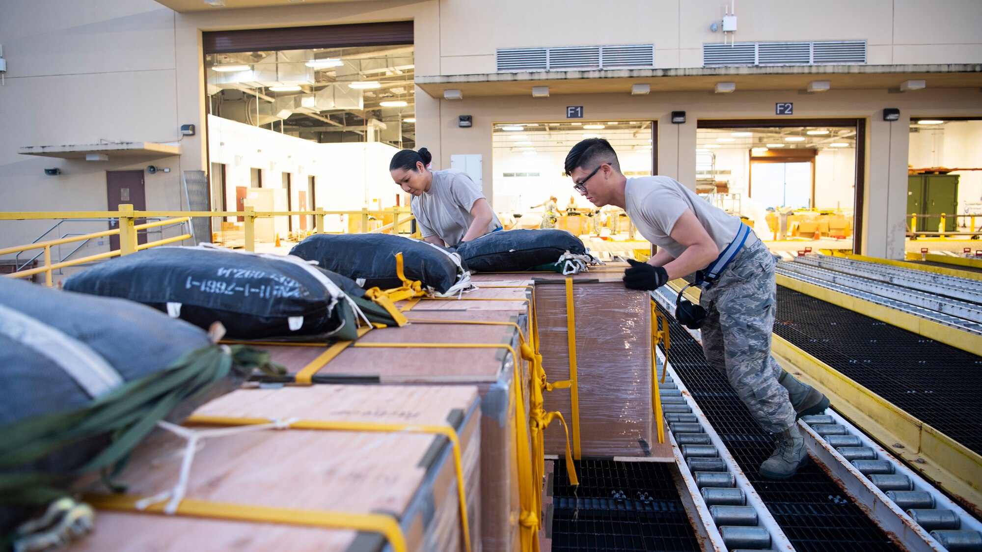 U.S. Air Force Senior Airman Yvonne Manglona and Airman Willy Hong, both air transportation specialist with the U.S. Air Force Reserve’s 44th Aerial Port Squadron, preposition airdrop bundles ready for transportation out to awaiting aircraft Dec 9, 2018, during Operation Christmas Drop at Andersen Air Force Base, Guam. Operation Christmas Drop is a U.S. Air Force-led trilateral training event that includes air support from the Japanese Air Self Defense Force and Royal Australian Air Force to airdrop supplies to the Commonwealth of the Northern Marianas, Federated States of Micronesia, and the Republic of Palau. (U.S. Air Force photo by Jerry R. Bynum)