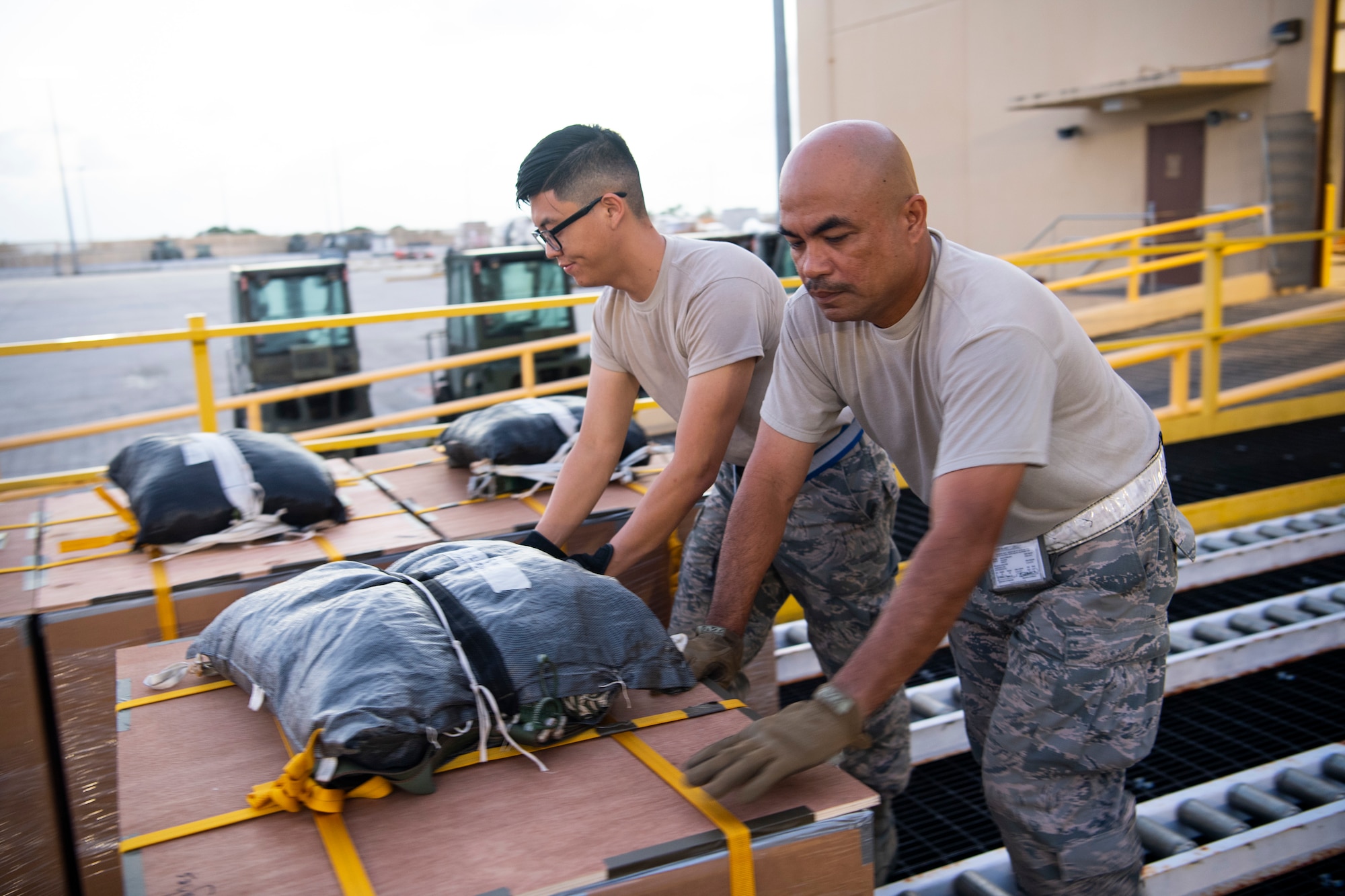 U.S. Air Force Airman Willy Hong (left to right) and Master Sgt. Rene Molinos, both air transportation specialist with the U.S. Air Force Reserve’s 44th Aerial Port Squadron, preposition airdrop bundles ready for transportation out to awaiting aircraft Dec 9, 2018, during Operation Christmas Drop at Andersen Air Force Base, Guam. Operation Christmas Drop is a U.S. Air Force-led trilateral training event that includes air support from the Japanese Air Self Defense Force and Royal Australian Air Force to airdrop supplies to the Commonwealth of the Northern Marianas, Federated States of Micronesia, and the Republic of Palau. (U.S. Air Force photo by Jerry R. Bynum)