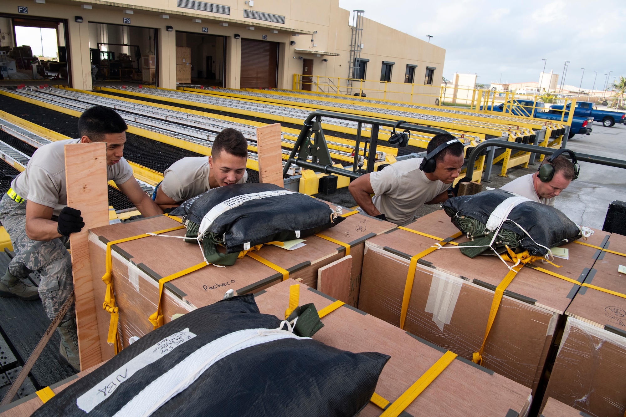 U.S. Air Force Airman 1st Class Joshua San Agustin (left-right), Airman Giovanni Manglona, Airman Brandon Phillip and Master Sgt. David Popp, all air transportation specialist with the U.S. Air Force Reserve’s 44th Aerial Port Squadron, load and secure airdrop bundles onto a Tunner 60K aircraft loader for transportation out to awaiting aircraft Dec. 11, 2018, during Operation Christmas Drop at Andersen Air Force Base, Guam. Operation Christmas Drop is a U.S. Air Force-led trilateral training event that includes air support from the Japanese Air Self Defense Force and Royal Australian Air Force to airdrop supplies to the Commonwealth of the Northern Marianas, Federated States of Micronesia, and the Republic of Palau. (U.S. Air Force photo by Jerry R. Bynum)