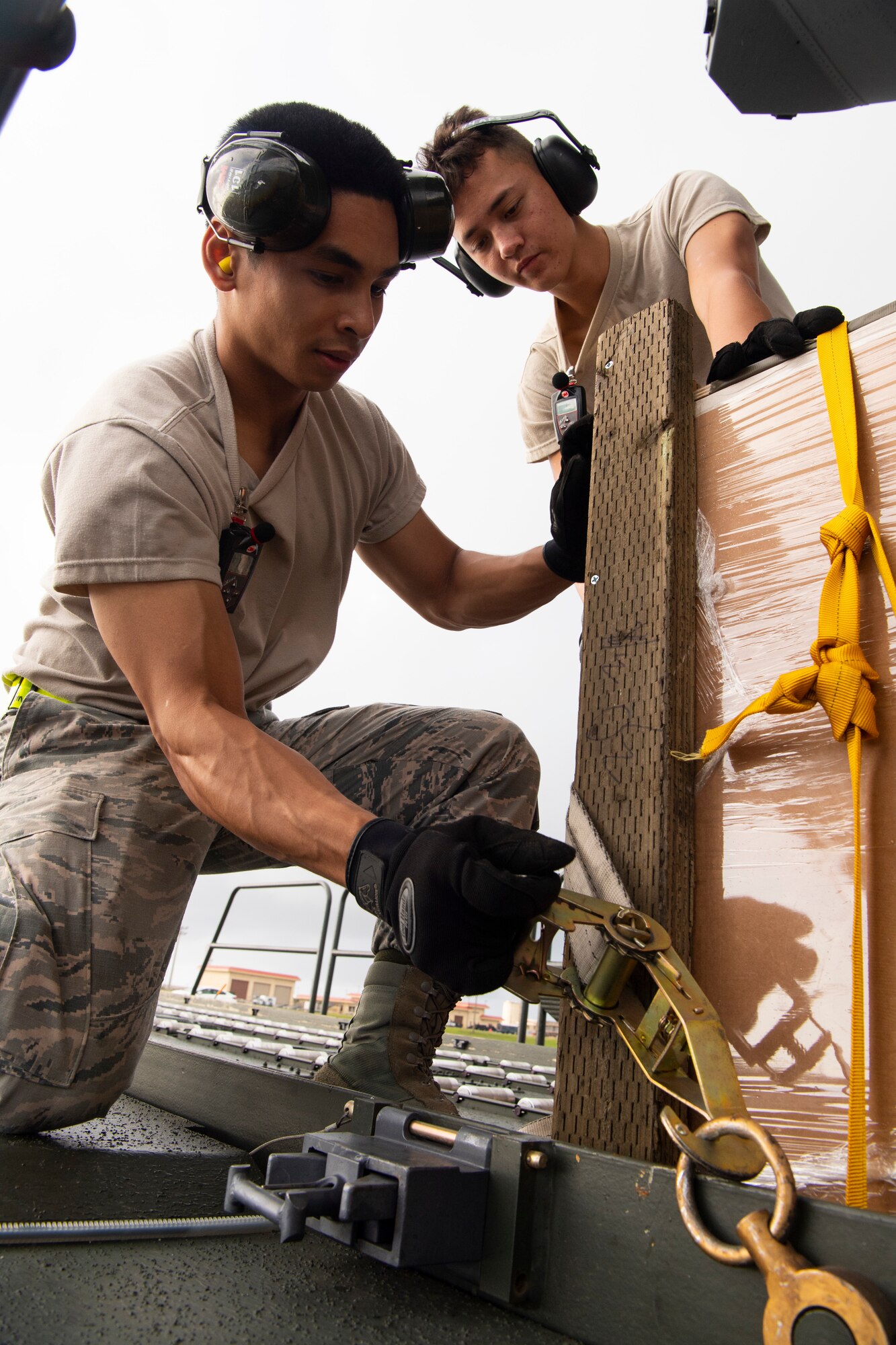 U.S. Air Force Airman 1st Class Joshua San Agustin (left to right) and Airman Giovanni Manglona, both air transportation specialist with the U.S. Air Force Reserve’s 44th Aerial Port Squadron, secure airdrop bundles onto a Tunner 60K aircraft loader for transportation out to awaiting aircraft Dec. 11, 2018, during Operation Christmas Drop at Andersen Air Force Base, Guam. Operation Christmas Drop is a U.S. Air Force-led trilateral training event that includes air support from the Japanese Air Self Defense Force and Royal Australian Air Force to airdrop supplies to the Commonwealth of the Northern Marianas, Federated States of Micronesia, and the Republic of Palau. (U.S. Air Force photo by Jerry R. Bynum)