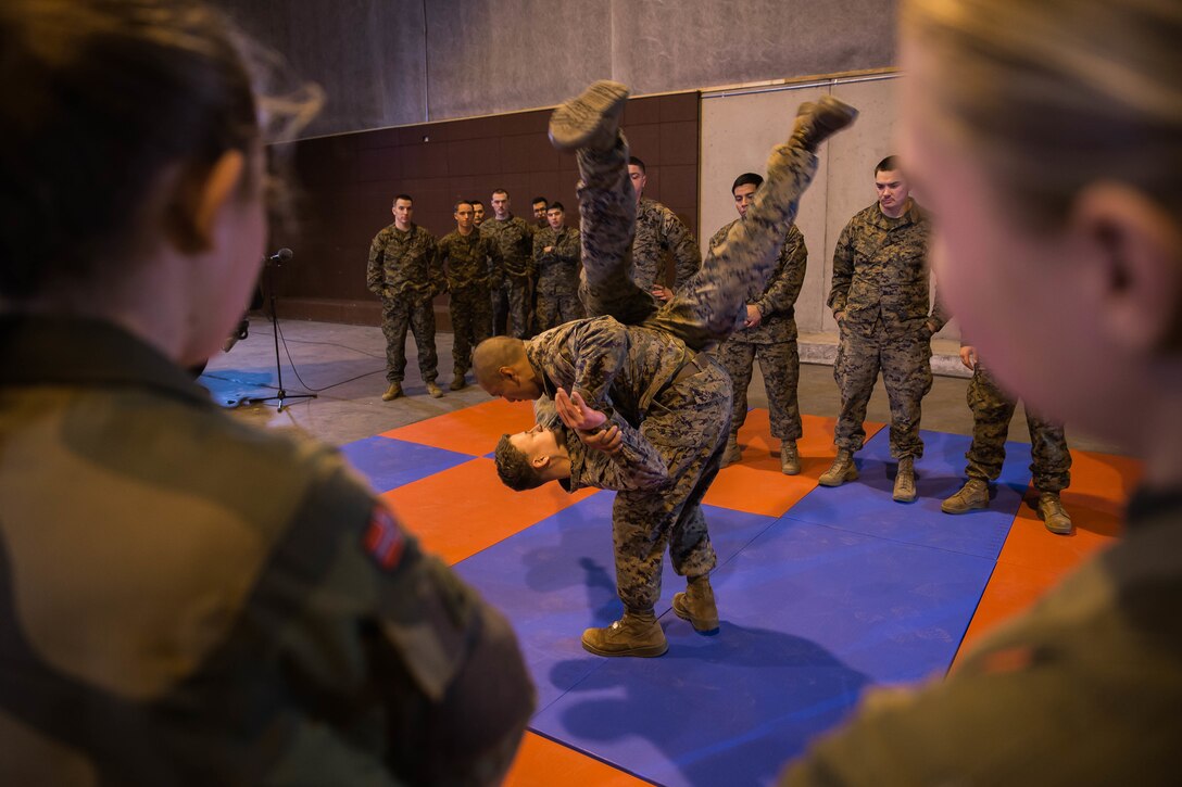 U.S. Marines with Marine Rotational Force Europe 19.1 (MRF-E) teach Marine Corps Martial Arts Program (MCMAP) techniques to Norwegian Soldiers during a live broad-cast for “NRK Norwegian Network” at Vaernes Air Base, Norway, Nov. 19, 2018. The MRF-E Marines were selected to be the participants of a Norwegian talk show known as Norge Na (Norway Now). The talk show will inform the Norwegian community about the mission of MRF-E 19.1 and explain how the deployment has bolstered the local community of Stjørdal, Norway. (U.S. Marine Corps photo by Cpl. Elijah Abernathy/Released)