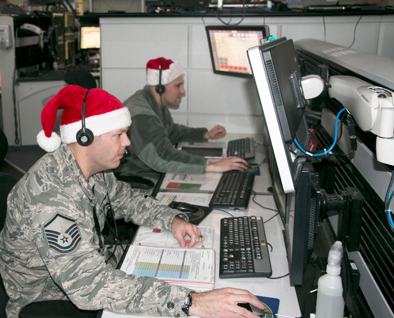 New York Air National Guards Master Sgt. Shane Reid, front, and Tech. Sgt. Brady King, both of the 224th Air Defense Squadron, train for upcoming Santa tracking operations at the Eastern Air Defense Sector in Rome. A headquarters unit of the North American Aerospace Defense Command (NORAD), EADS supports the NORAD Tracks Santa operation every year.