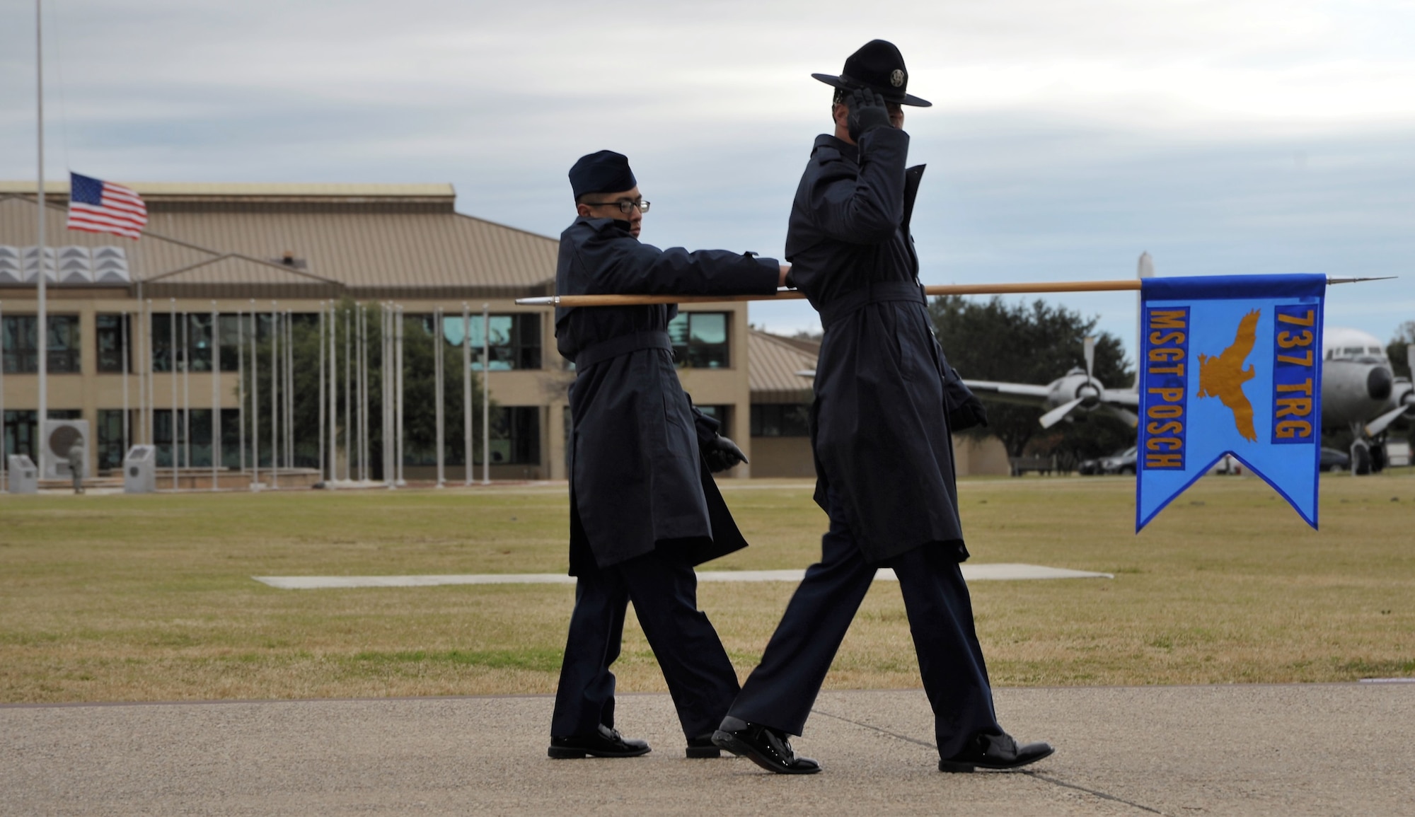 A 433rd Training Squadron basic military training instructor and trainee salute the reviewing official and distinguished guests during the Dec. 14 BMT graduation at Joint Base San Antonio-Lackland, Texas. This flight was named in honor of fallen Reserve Citizen Airmen Pararescueman Master Sgt. William Posch.  (U.S. Air Force photo by Debbie Gildea)
