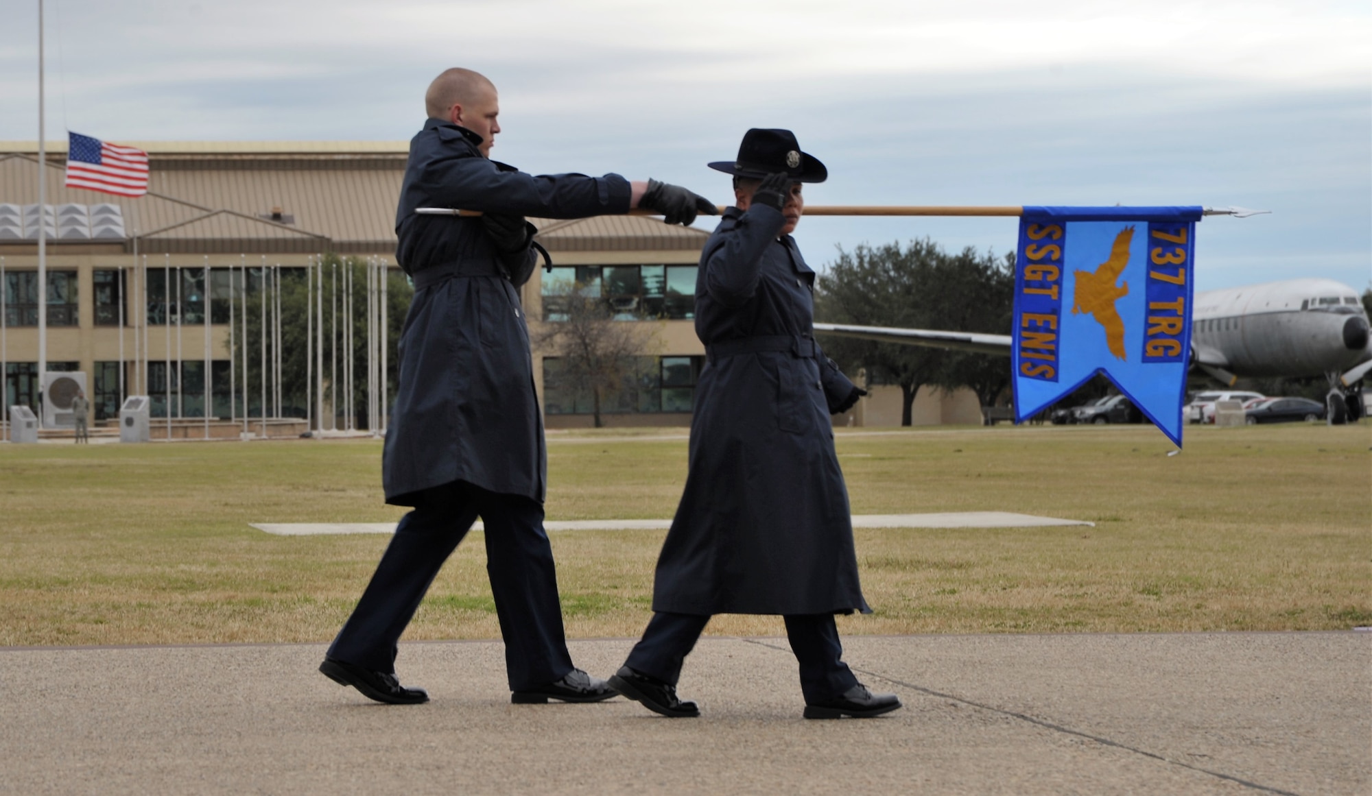 A 433rd Training Squadron basic military training instructor and trainee salute the reviewing official and distinguished guests during the Dec. 14 BMT graduation at Joint Base San Antonio-Lackland, Texas. This flight was named in honor of fallen Reserve Citizen Airmen Pararescueman Staff Sgt. Carl Enis.  (U.S. Air Force photo by Debbie Gildea)