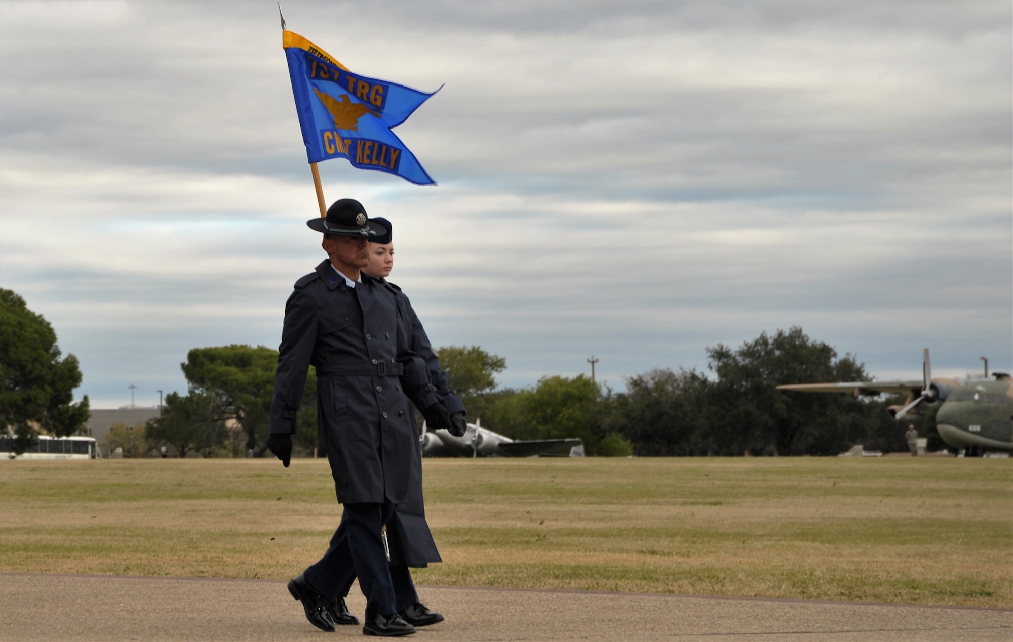 A 433rd Training Squadron basic military training instructor and trainee present the flight pennant during the Dec. 14 BMT graduation at Joint Base San Antonio-Lackland, Texas. This flight was named in honor of Chief Master Sgt. Ericka Kelly, command chief for Air Force Reserve Command, whose story is the epitome of determination, empowerment and resilience.  (U.S. Air Force photo by Debbie Gildea)