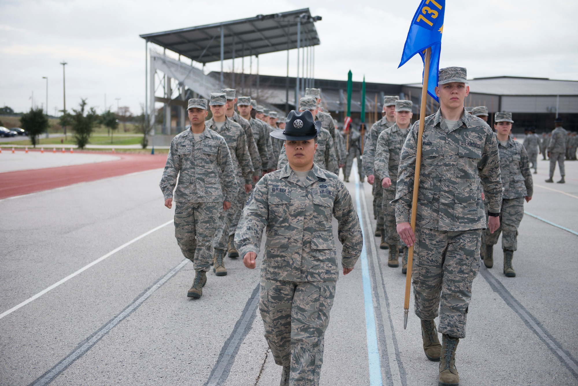 Military Training Instructor Tech. Sgt. Christina Rapolla, 433rd Training Squadron Reserve Citizen Airman, leads her flight in drill during the early weeks of basic military training. Attention to detail, discipline and teamwork learned at this stage enabled trainees to succeed and graduate during ceremonies held here Dec. 14. (U.S. Air Force photo by Sy Pinthong)