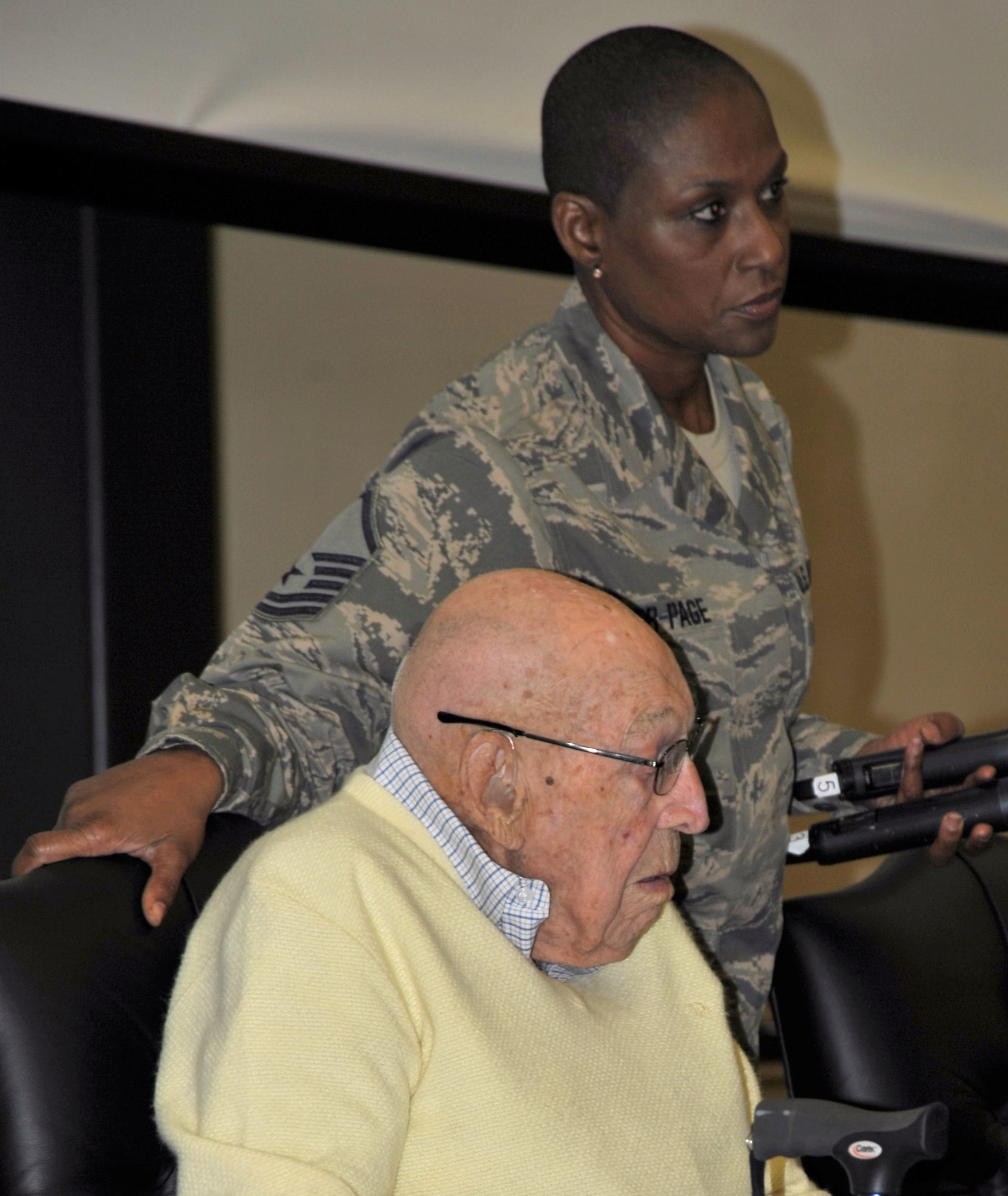 Master Sgt. Rosalind Rider-Page, 433rd Training Squadron, prepares to assist Retired Lt. Col. Dick Cole from the stage following his question-and-answer session at Joint Base San Antonio-Lackland on Dec. 13. Colonel Cole is the last living member of the World War II Doolittle Raiders. He and his daughter were special guests of the 433rd Training Squadron during basic military training graduation week activities. (U.S. Air Force photo by Debbie Gildea)