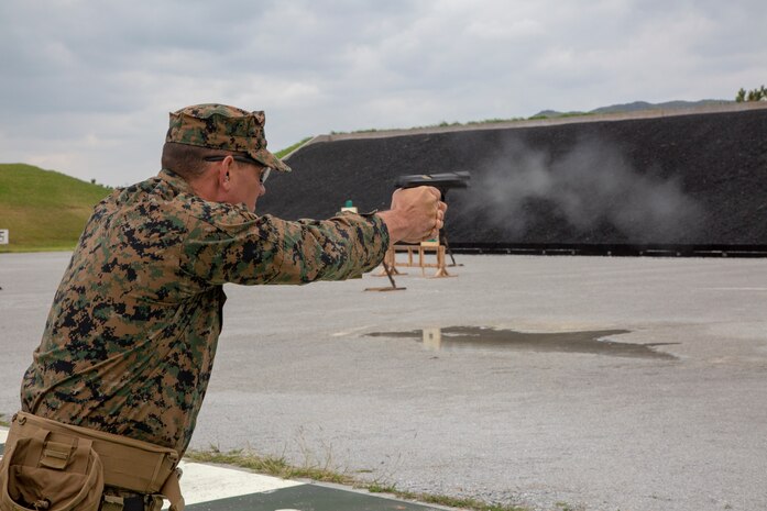A U.S. Marine competing in the Far East Marksmanship Competition fires a round at Range 1 on Camp Hansen, Okinawa, Japan Dec. 13, 2018. The M9 is the standard issue pistol for the Marine Corps and fires a 9mm round.
