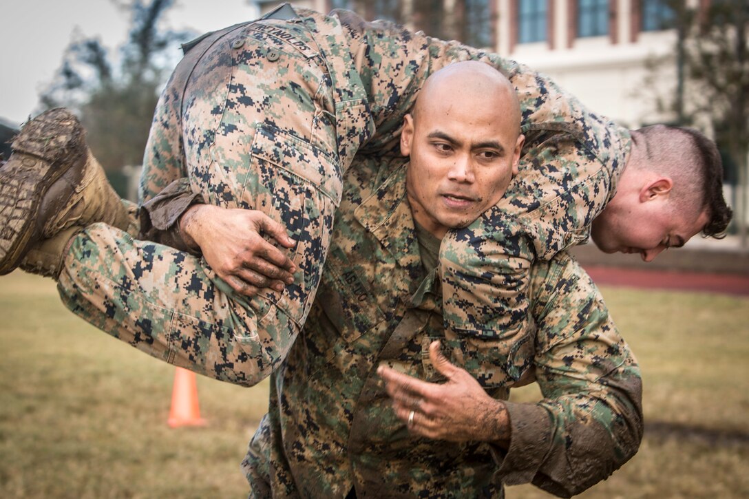 Gunnery Sgt. Cezar Abado, a capabilities chief with Marine Forces Reserve, fireman carries another Marine during the maneuver under fire portion of the Combat Fitness Test at Marine Corps Support Facility New Orleans, Dec. 14, 2018. The CFT is an annual fitness assessment comprised of a simulated movement to contact, which is an 880-meter sprint; 2 minutes of 30-pound ammo can lifts, and a maneuver under fire, which is a timed 300-yard shuttle run of combat-related tasks. (U.S. Marine Corps photo by Cpl. Tessa D. Watts)
