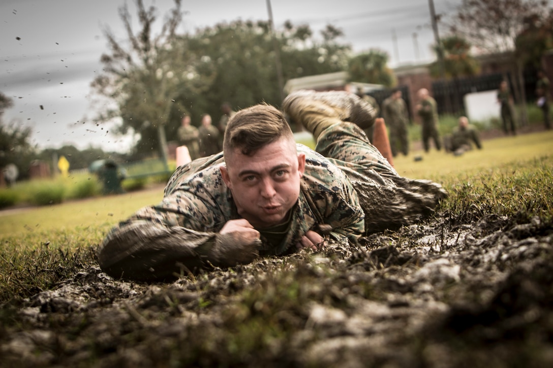 Cpl. Darrell Reynolds, the fiscal chief with 4th Marine Logistics Group, Marine Forces Reserve, low crawls during the maneuver under fire portion of the Combat Fitness Test at Marine Corps Support Facility New Orleans, Dec. 14, 2018. The CFT is an annual fitness assessment comprised of a simulated movement to contact, which is an 880-meter sprint; 2 minutes of 30-pound ammo can lifts, and a maneuver under fire, which is a timed 300-yard shuttle run of combat-related tasks. (U.S. Marine Corps photo by Cpl. Tessa D. Watts)