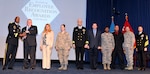 DLA Director and DLA Navy Senior Enlisted Leader present a group award to a team of eight people.