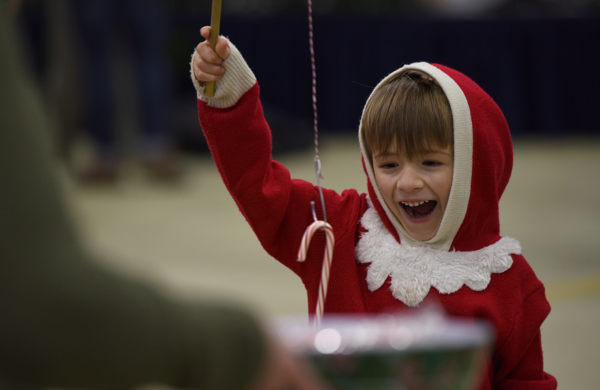 A 48th Fighter Wing Children’s Holiday Party guest catches a candy cane with a fishing pole at Royal Air Force Lakenheath, England, Dec. 15, 2018. Party festivities included bouncy houses, holiday crafts, and a photo opportunity with Santa Claus. (U.S. Air Force photo by Madeline Herzog)