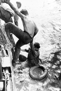 IMAGE: Oct. 25, 1944: American survivors of the battle are rescued by a U.S. Navy ship on Oct. 26, 1944. Some 1,200 survivors of USS Gambier Bay (CVE-73), USS Hoel (DD-533), USS Johnston (DD-557) and USS Samuel B. Roberts (DE-413) were rescued during the days following the action. Photographed by U.S. Army Private William Roof/Photograph from the Army Signal Corps Collection in the U.S. National Archives