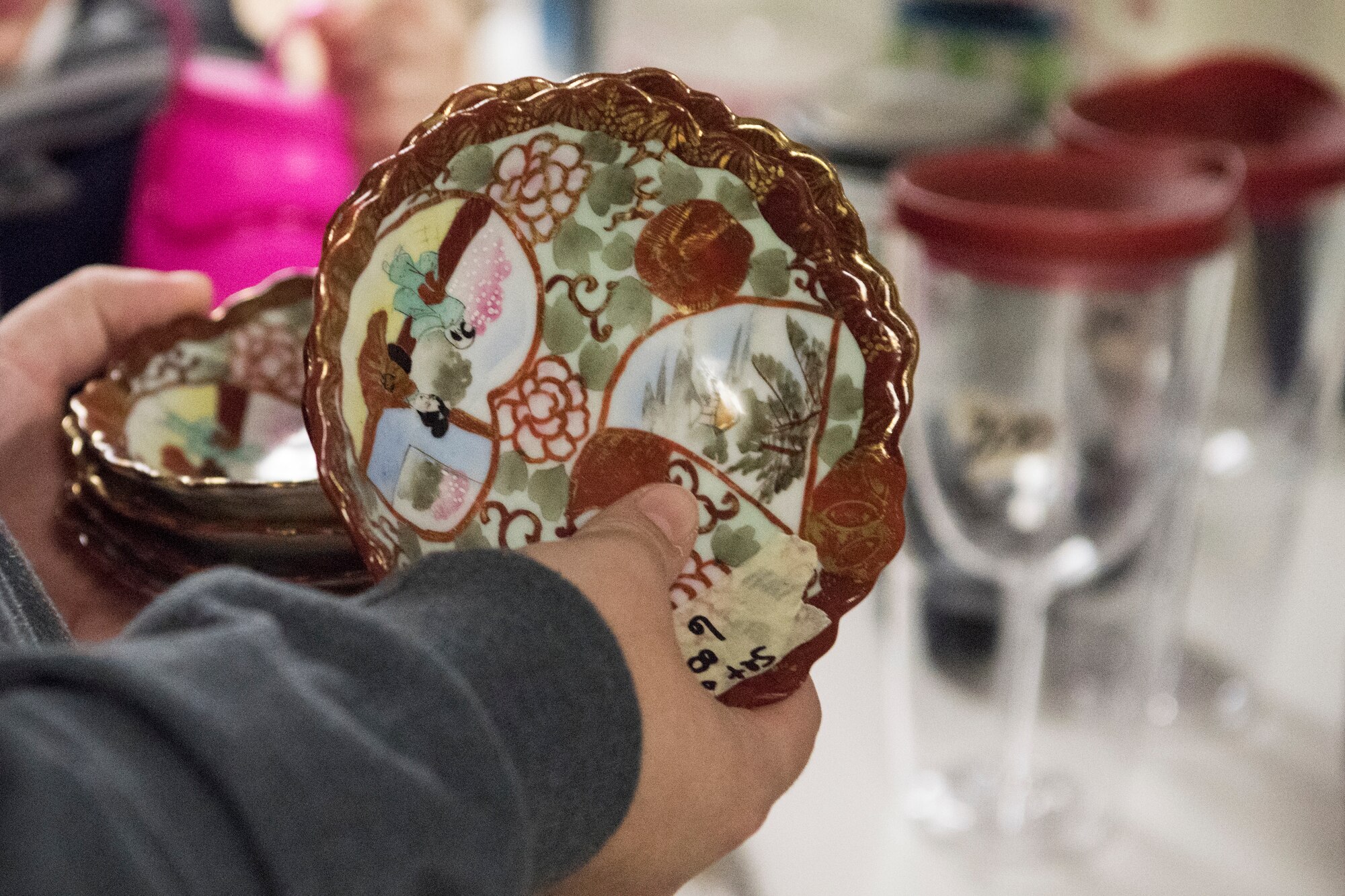 Tiffani Johnson, wife of U.S. Air Force Senior Airman Jacob Johnson, a 301st Intelligence Squadron fusion analyst, holds a dish at the Fort Richardson Thrift Shop, Joint Base Elmendorf-Richardson, Alaska Dec. 12, 2018. The store is open to all branches of active duty, the National Guard, Reserve, retired military personnel, their dependents and anyone with access to JBER.