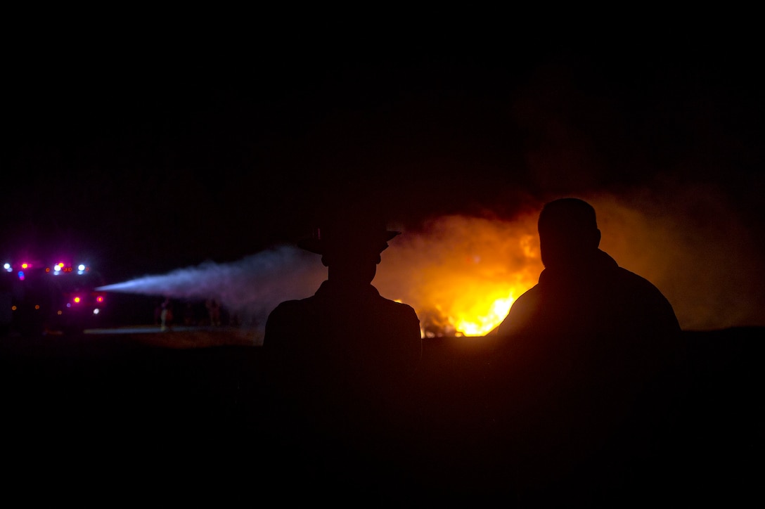 Valdosta Fire Department members watch the 23d Civil Engineer Squadron extinguish a simulate aircraft fire during live-fire training, Nov. 29, 2018, at Moody Air Force Base, Ga. The units strengthened their alliance and firefighting capabilities by jointly extinguishing a simulated aircraft fire to maintain their Airport Rescue and Firefighting proficiency. (U.S. Air Force photo by Senior Airman Greg Nash)