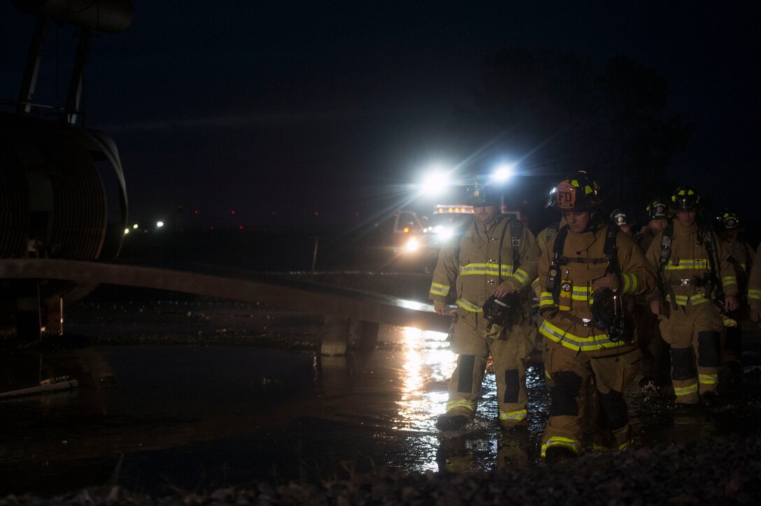 Firefighters from the 23d Civil Engineer Squadron and Valdosta Fire Department prepare to conduct live-fire training, Nov. 29, 2018, at Moody Air Force Base, Ga. The units strengthened their alliance and firefighting capabilities by jointly extinguishing a simulated aircraft fire to maintain their Airport Rescue and Firefighting proficiency. (U.S. Air Force photo by Senior Airman Greg Nash)