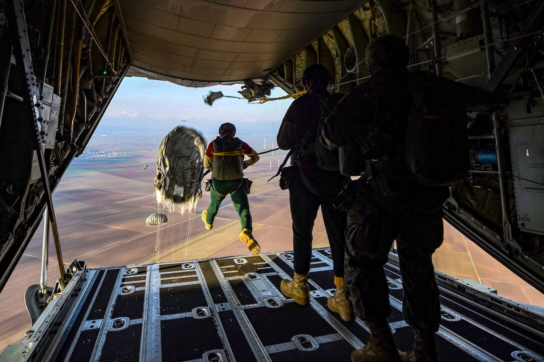 Airmen dressed as elves jump from a plane.