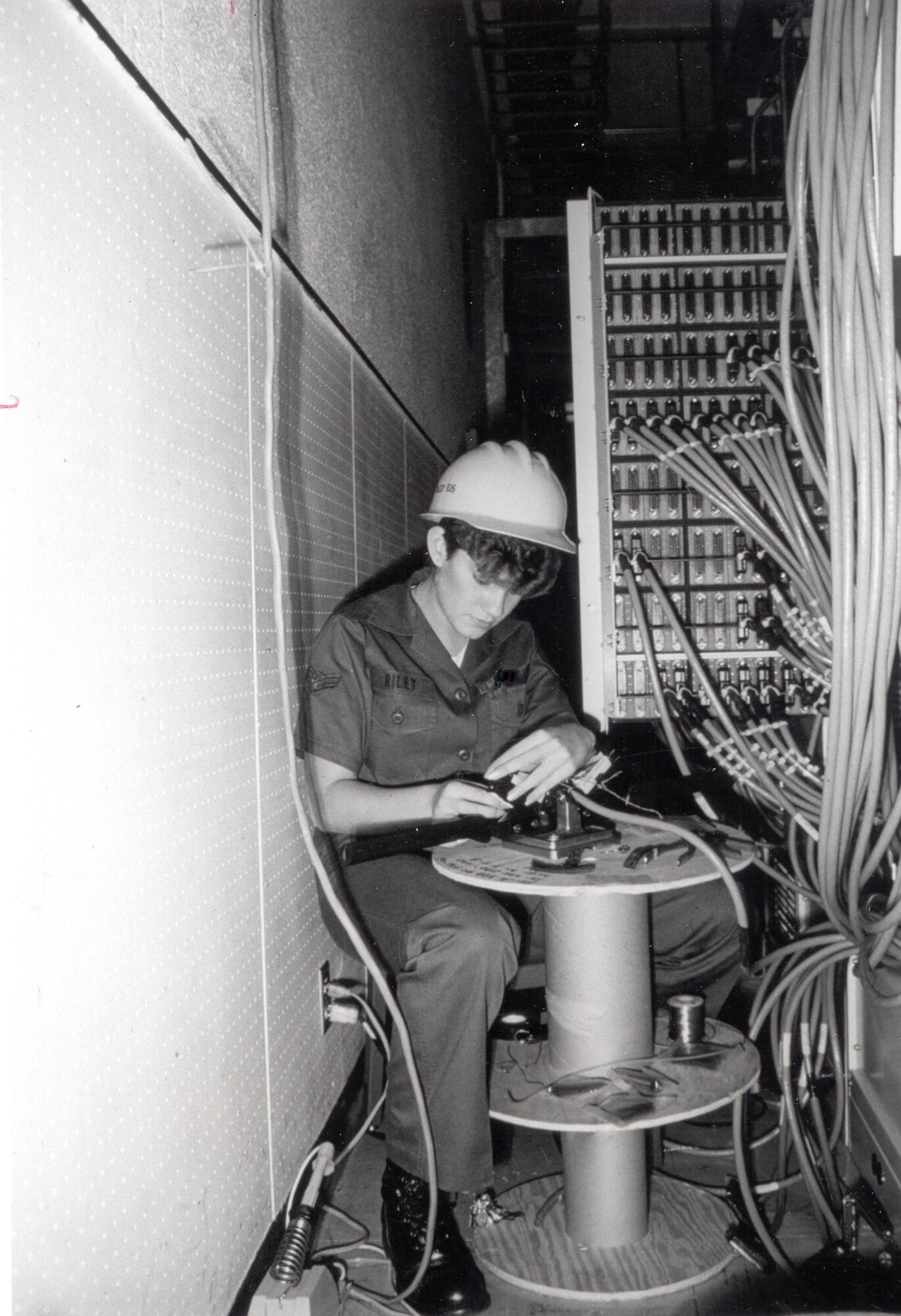 Sharnee Riley, 1837th Engineering Installation Squadron, uses an Amphanol "Amp-Champ" crimper to terminate a connector on one of the multitude of 25-pair cables installed at the control site as part of the Scope Signal III installation to modernize Giant Talk, the Strategic Air Command's world-wide command and controls network, Clark AB, Philippines.