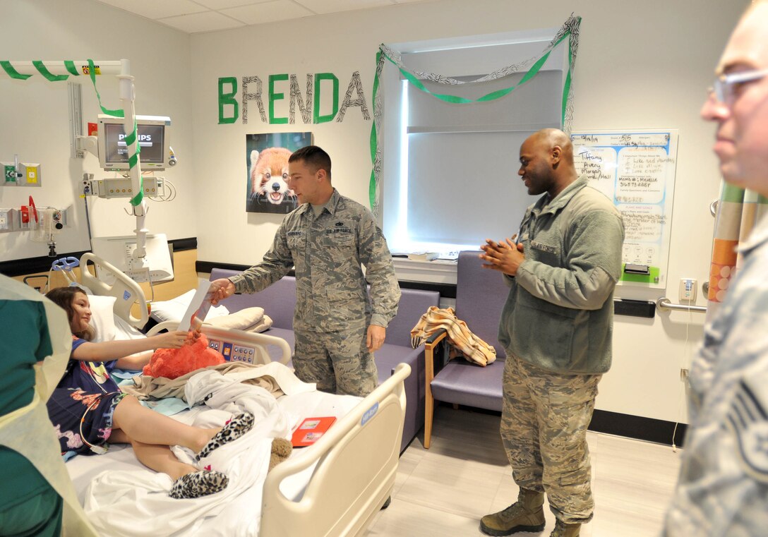 Staff Sgt. Cody Verbanac, 373rd Training Squadron, Det. 8 KC-46 Pegasus fuel systems instructor, hands a puzzle to a child Dec. 18, 2018, at Wesley Children’s Hospital. The maintenance Airmen spread some holiday cheer throughout the hospital to the children having to stay there. (U.S. Air Force photo by Staff Sgt. David Bernal Del Agua)