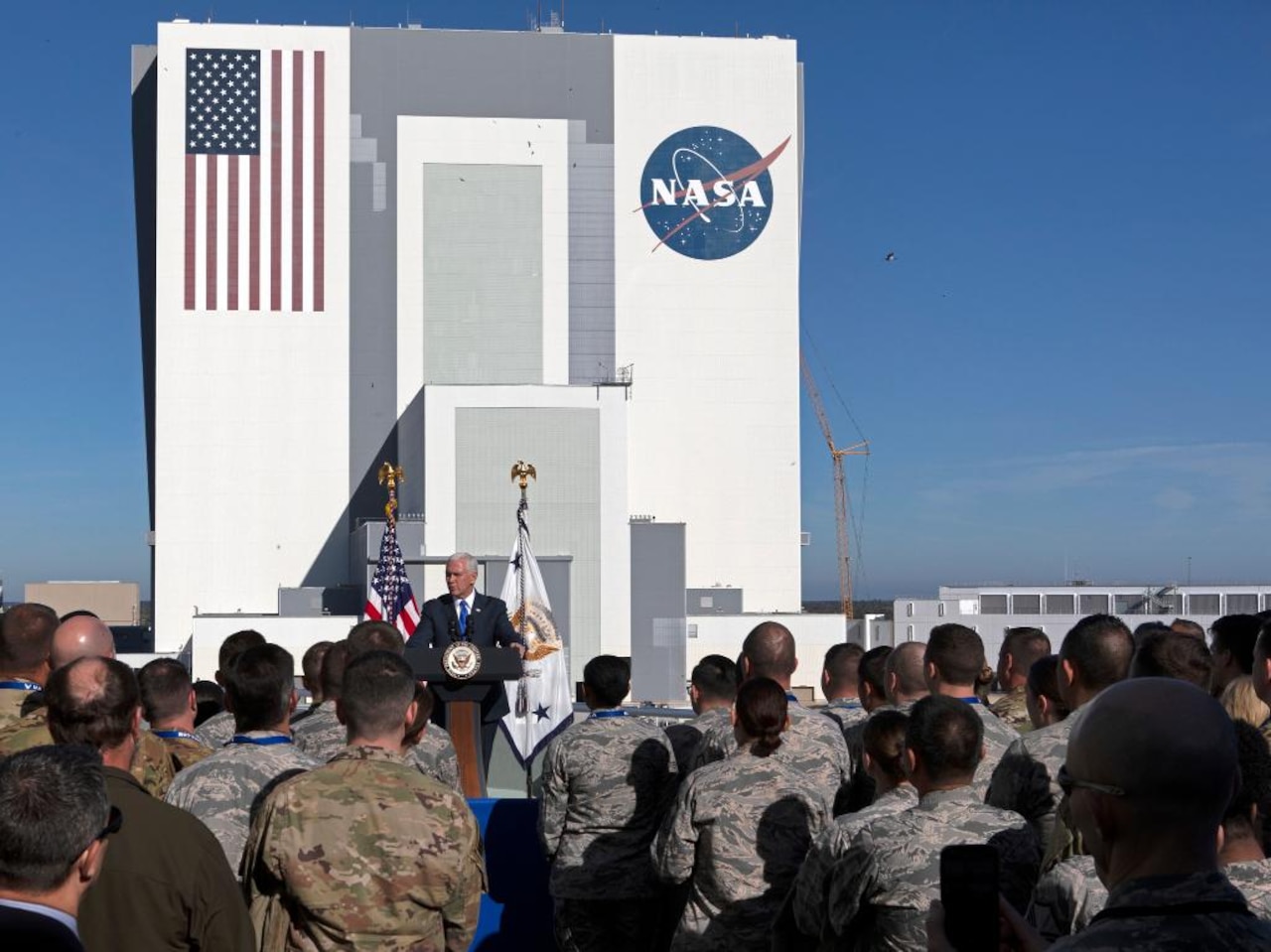 Vice President Mike Pence stands on stage talking to a large group of people