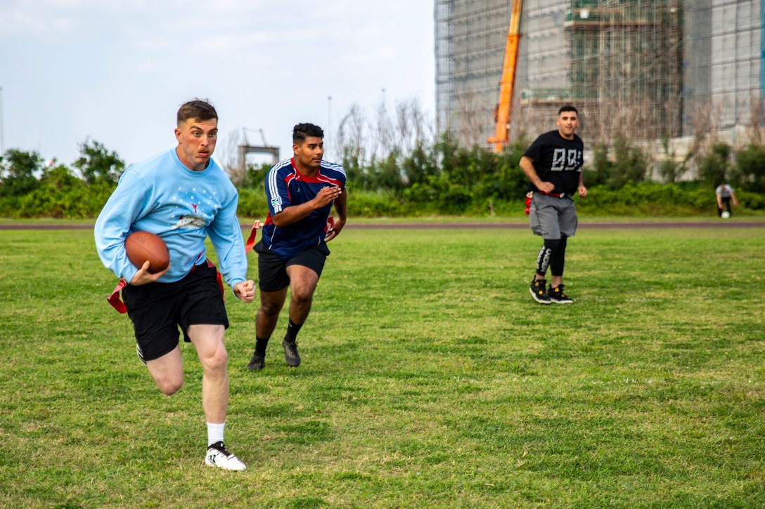 Lance Cpl. Mark Fike sprints to score a touchdown during a flag football game at the fourth annual Reindeer Games on Camp Kinser, Okinawa, Japan, Dec. 18, 2018. The Reindeer Games are a holiday-themed, family event held to boost morale and camaraderie among the Marines, Sailors and families of Combat Logistics Regiment 37, 3rd Marine Logistics Group. Fike, a combat mass communicator with Communication Strategy and Operations, 3rd MLG Headquarters, is a native of Farmington, Pennsylvania. (U.S. Marine Corps photo by Cpl. Joshua Pinkney)