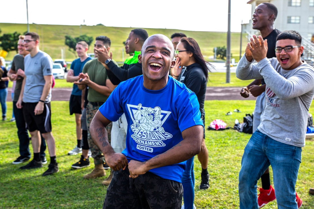 Cpl. Kendall Wilson shouts support for his fellow Marines during a grappling match at the fourth annual Reindeer Games on Camp Kinser, Okinawa, Japan, Dec. 18, 2018. The Reindeer Games are a holiday-themed, family event held to boost morale and camaraderie among the Marines, Sailors and families of Combat Logistics Regiment 37, 3rd Marine Logistics Group. Wilson, a native of Fort Worth, Texas, is an embarkation specialist with Headquarters Company, CLR-37, 3rd MLG. (U.S. Marine Corps photo by Cpl. Joshua Pinkney)