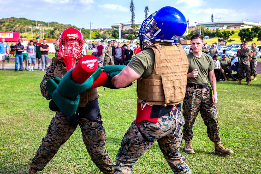 Sgt. Justin Boetger, left, strikes Sgt. Jonathan Kurt Smith during a pugil stick bout at the fourth annual Reindeer Games on Camp Kinser, Okinawa, Japan, Dec. 18, 2018. The Reindeer Games are a holiday-themed, family event held to boost morale and camaraderie among the Marines, Sailors and families of Combat Logistics Regiment 37, 3rd Marine Logistics Group. Boetger is a food service specialist with Headquarters Company, CLR-37, 3rd MLG and a native of Bakersfield, California. Smith is a radio maintenance technician with Communications Company, CLR-37, 3rd MLG, and a native of Charlotte, North Carolina. (U.S. Marine Corps photo by Cpl. Joshua Pinkney)