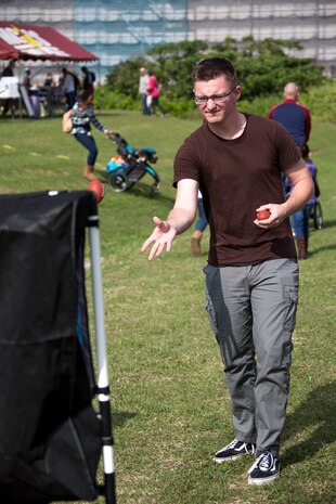 Cpl. Brett Johnson tosses a miniature football during the fourth annual Reindeer Games on Camp Kinser, Okinawa, Japan, Dec. 18, 2018. The Reindeer Games are a holiday-themed, family event held to boost morale and camaraderie among the Marines, Sailors and families of Combat Logistics Regiment 37, 3rd Marine Logistics Group. Johnson, a native of Mesa, Arizona, is a legal clerk with the Staff Judge Advocate office, 3rd MLG Headquarters. (U.S. Marine Corps photo by Lance Cpl. Terry Wong)