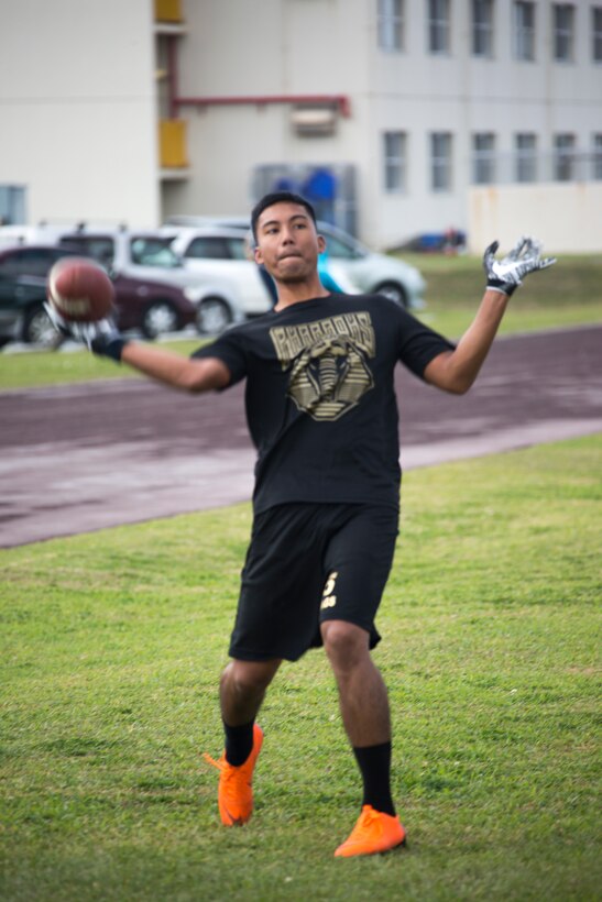 Sgt. William Y. Ragiles throws a football before a game during the fourth annual Reindeer Games on Camp Kinser, Okinawa, Japan, Dec. 18, 2018. The Reindeer Games are a holiday-themed, family event held to boost morale and camaraderie among the Marines, Sailors and families of Combat Logistics Regiment 37, 3rd Marine Logistics Group. Ragiles, a native of Waipahu, Hawaii, is a mess chief with Field Mess, Food Service Company, CLR-37, 3rd MLG. (U.S. Marine Corps photo by Lance Cpl. Terry Wong)