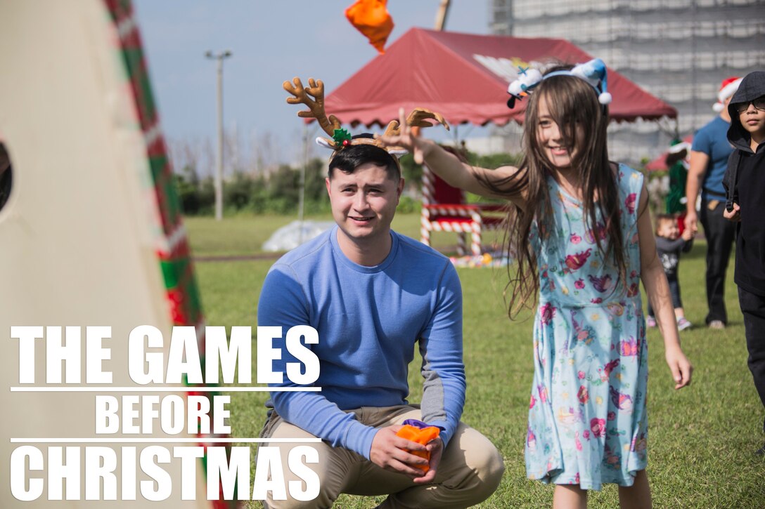 Sgt. Joshua T. Parrish watches as Amelia R. Beemster throws a beanbag during the 4th annual Reindeer Games Dec. 18, 2018 at Camp Kinser, Okinawa, Japan. The Reindeer Games are a holiday-themed, family event held to boost morale and camaraderie among the Marines, Sailors and families of Combat Logistics Regiment 37, 3rd Marine Logistics Group. Parrish, a native of Lexington, Alabama, is the staff noncommissioned officer in charge with S-6, Headquarters Company, CLR-37, 3rd MLG. (U.S. Marine Corps photo by Lance Cpl. Terry Wong)