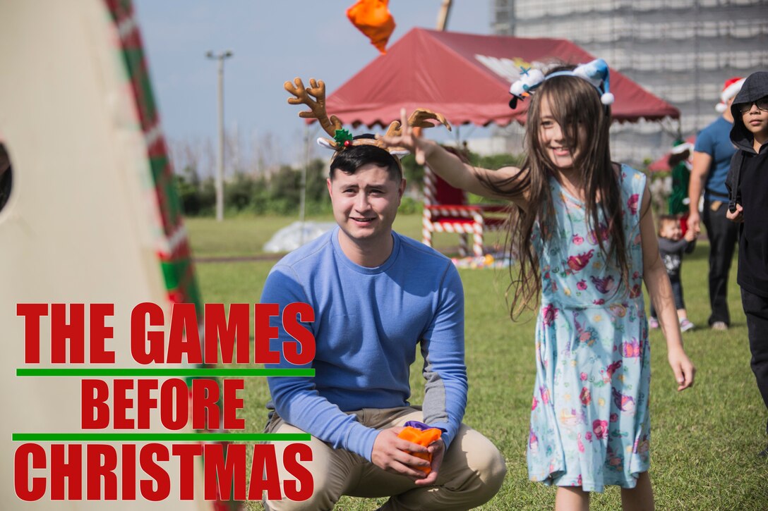 Sgt. Joshua T. Parrish watches as Amelia R. Beemster throws a beanbag during the 4th annual Reindeer Games Dec. 18, 2018 at Camp Kinser, Okinawa, Japan. The Reindeer Games are a holiday-themed, family event held to boost morale and camaraderie among the Marines, Sailors and families of Combat Logistics Regiment 37, 3rd Marine Logistics Group. Parrish, a native of Lexington, Alabama, is the staff noncommissioned officer in charge with S-6, Headquarters Company, CLR-37, 3rd MLG. (U.S. Marine Corps photo by Lance Cpl. Terry Wong)