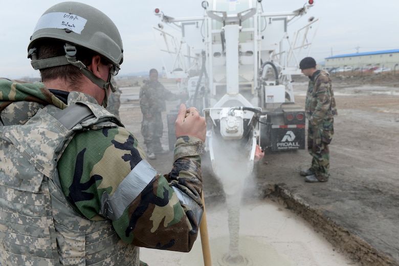 U.S. Air Force Staff Sgt. Clark Edwin, 8th Civil Engineer Squadron, Pavement and Equipment Operator, waits as concrete is poured into a hole near the airfield at Kunsan Air Base, Republic of Korea, Dec. 6, 2018. 8th CES teams worked to fill large holes as part of Rapid Airfield Damage Repair training. (U.S. Air Force photo by 1st Lt. Madeline Krpan)