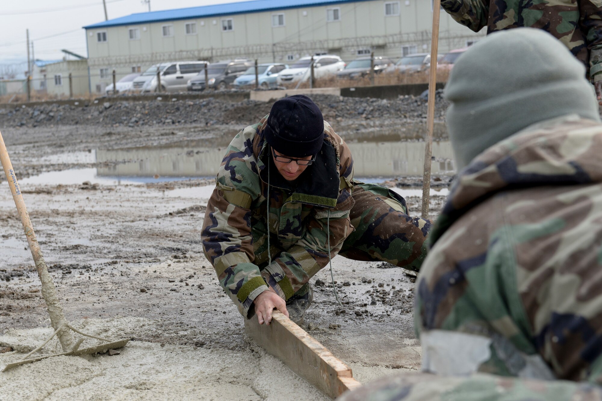 U.S. Air Force Staff Sgt. Travis Lowe, 8th Civil Engineer Squadron pavement and equipment operator, levels a section of wet concrete during Rapid Airfield Damage Repair training at Kunsan Air Base, Republic of Korea, Dec. 6, 2018. Maintaining a high level of proficiency in working with quick drying concrete is one critical aspect of being able to quickly repair damage to the airfield under different conditions. (U.S. Air Force photo by 1st Lt. Madeline Krpan)