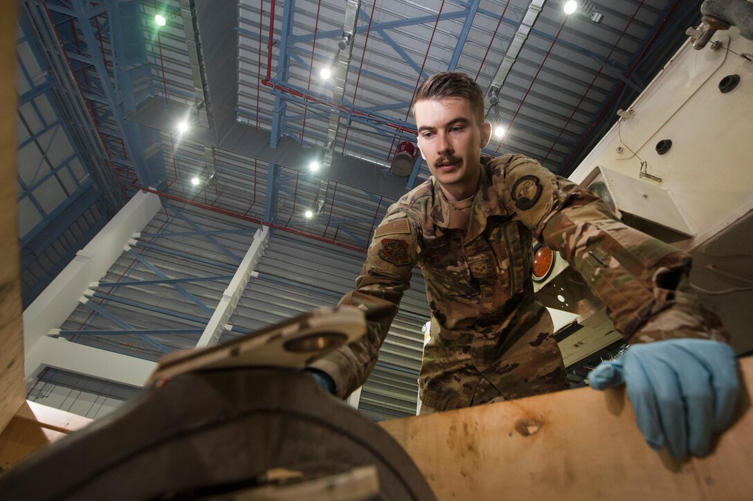 Senior Airman Porter Elliott, 8th Expeditionary Aircraft Maintenance Squadron (EAMS) crew chief, prepares a pitch trim actuator for installation in a C-17 Globemaster III Dec. 18, 2018, at Al Udeid Air Base, Qatar. This is the first time a maintenance procedure like this has been done in U.S. Air Forces Central Command’s area of responsibility. Due to safety concerns, Airmen from the 8th EAMS and 379th Expeditionary Civil Engineer Squadron combined capabilities to ensure the aircraft could be repaired prior to returning to home station. (U.S. Air Force photo by Tech. Sgt. Christopher Hubenthal)