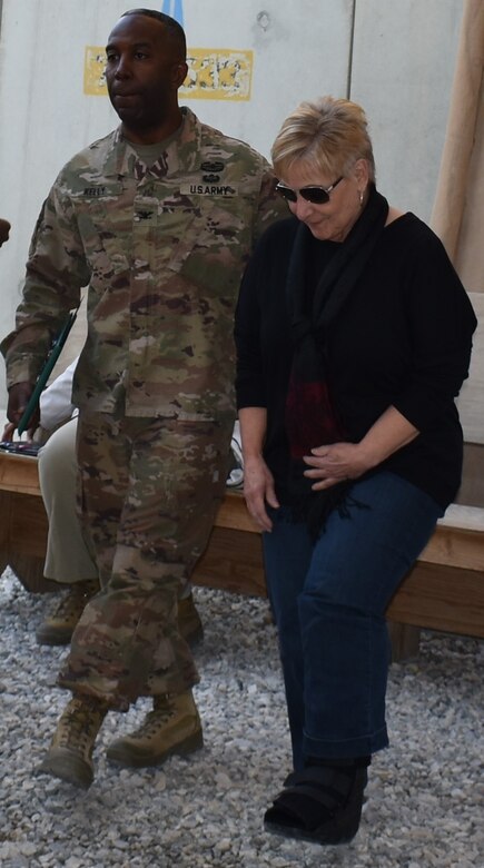 Col Jason Kelly assists Bonnie Corbin across the rocky terrain as a week before her scheduled departure from Bagram she injured her left foot.