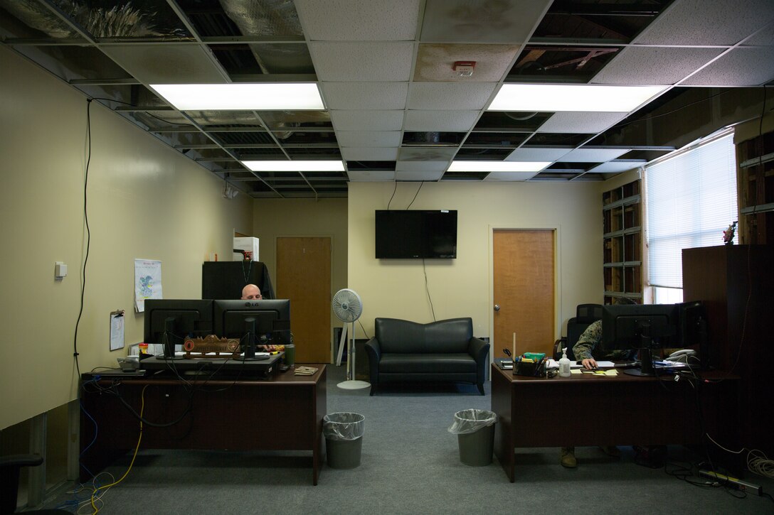 U.S. Marines continues to perform their duties inside the II Marine Expeditionary Force Headquarters building at Camp Lejeune, N.C., Dec. 11, 2018, despite working in an office with extensive hurricane damage. Contractors were required to remove most of the drywall and ceiling tiles. Three months after Hurricane Florence, damage like this can still be seen at various places throughout the building. However, Marines continue to utilize these workspaces or condense into other offices with less damage. (U.S. Marine Corps photo by Cpl. Austyn Saylor)