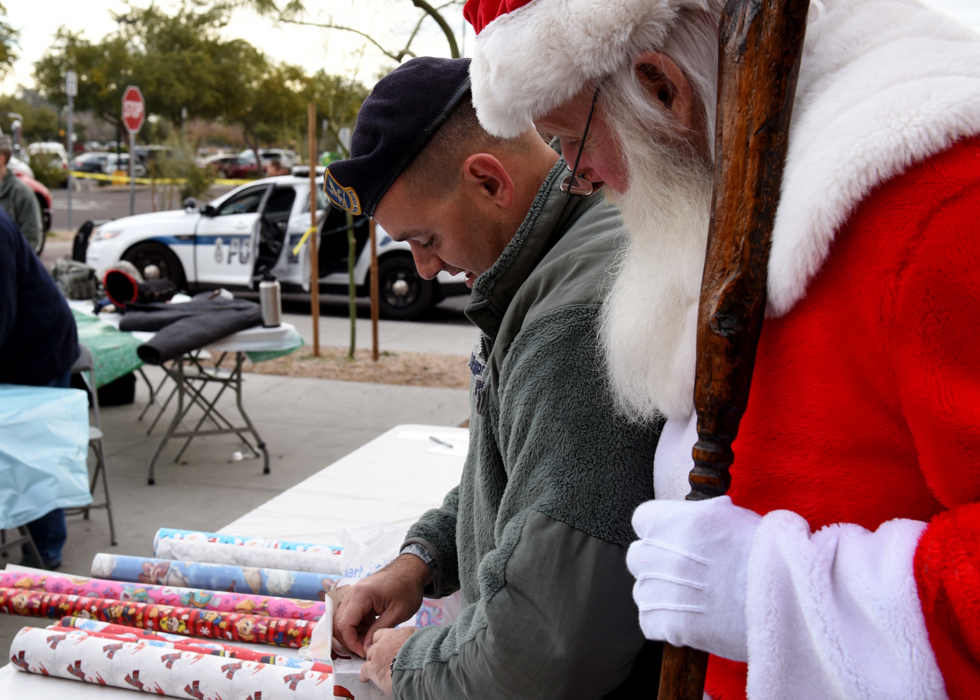 Staff Sgt. Eric Creekmore, 56th Security Force Squadron investigator, wraps presents with Santa at the Glendale Shop with a Cop event, in Glendale, Ariz., Dec. 15, 2018.