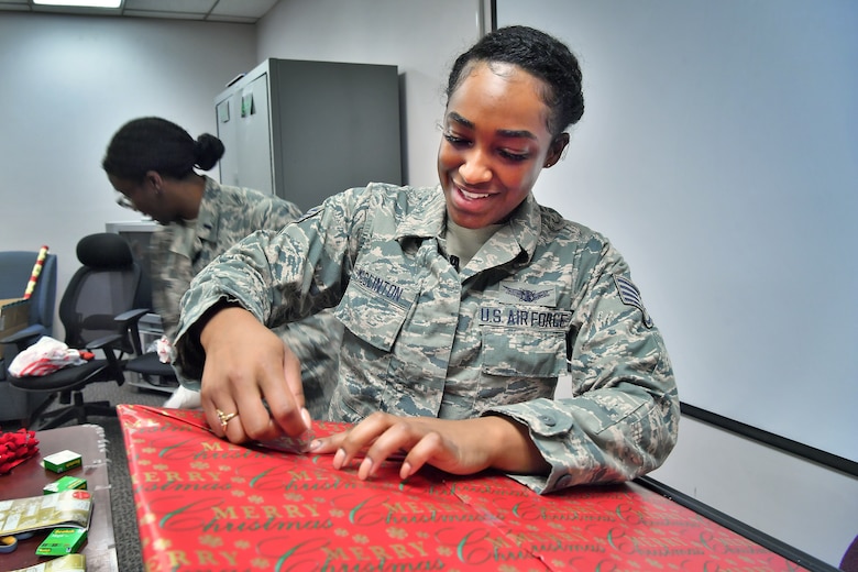 SCHRIEVER AIR FORCE BASE, Colo. -- Staff Sgt. Essence McClinton, 4th Space Operations Squadron Advanced Satellite Mission Control Subsystem operator, wraps a gift for the Angel Tree gift giving program in the chaplain resource room at Schriever Air Force Base, Colorado, Dec. 17, 2018. The presents wrapped will go to 54 children with a value of approximately 4 thousand dollars, which will be delivered to the Angel Tree Program recipients. (U.S. Air Force photo by Dennis Rogers)