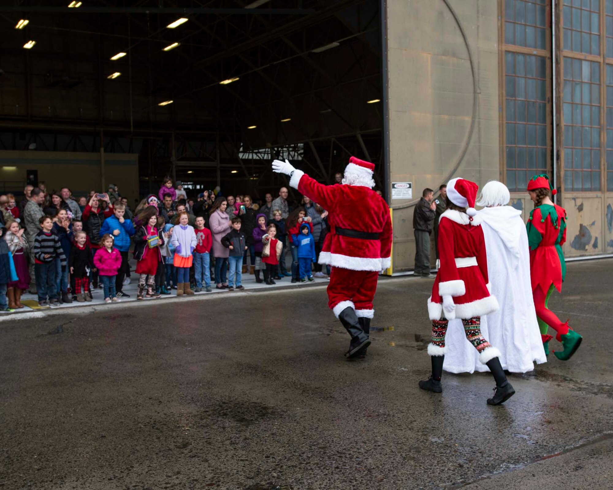 Santa Claus, along with Mrs. Claus and two elves, greet families awaiting them during the 141st Air Refueling Wing’s annual Winter Fest Dec. 1, 2018 at Fairchild Air Force Base, Wash. More than 900 Airmen assigned to the 141st are welcome to take part in the festivities along with their families to celebrate the holiday season. (U.S. Air National Guard photo by Staff Sgt. Rose M. Lust/Released)