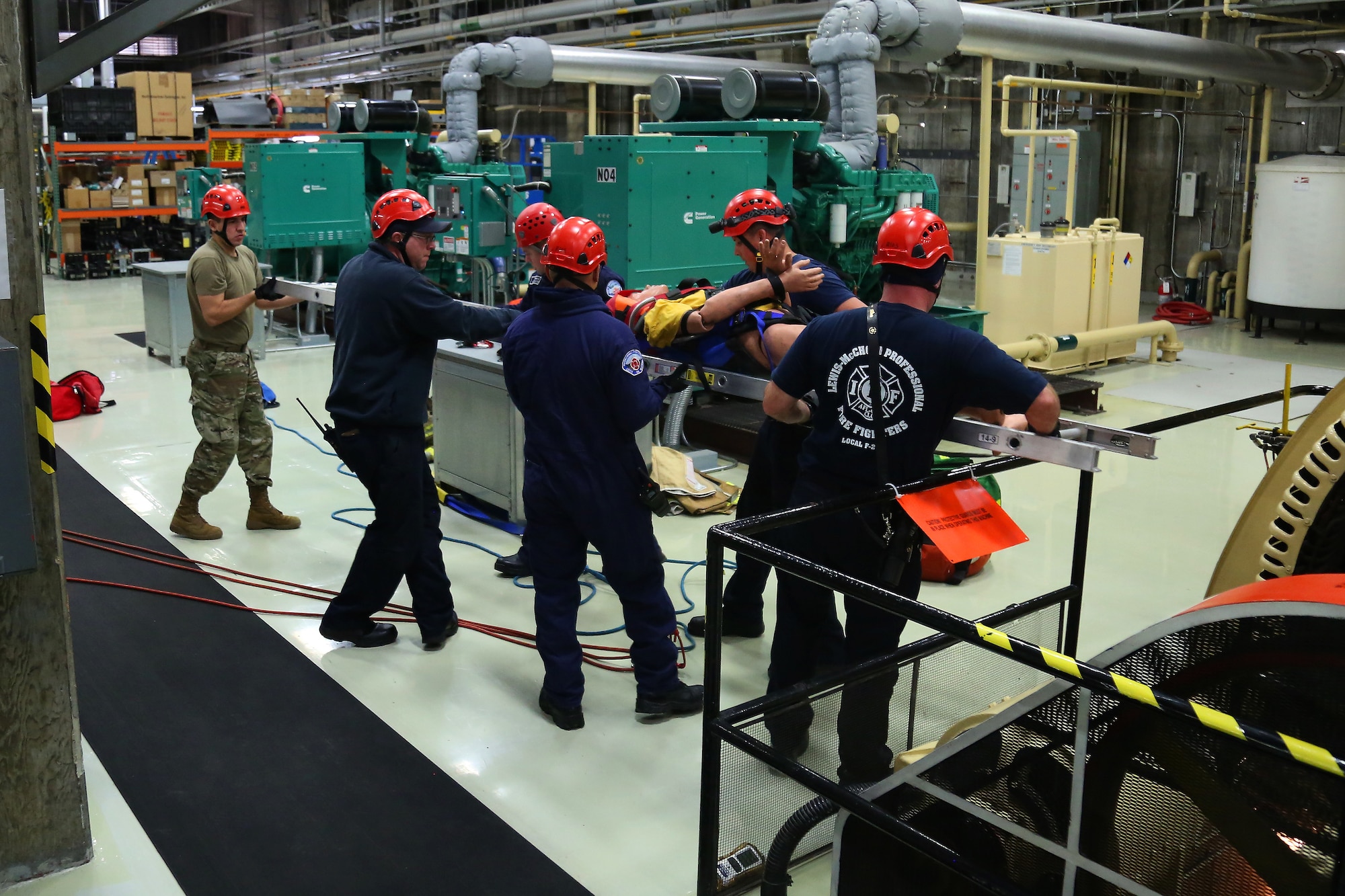 Joint Base Lewis-McChord first responders remove a simulated patient out of a generator pit during confined space rescue training at the Western Air Defense Sector Nov. 11, 2018, on Joint Base Lewis-McChord, Washington. The fire fighters were able to retrieve the patient in less than 40 minutes from the time of the call. (U.S. Air National Guard photo by Master Sgt. Tim Chacon)