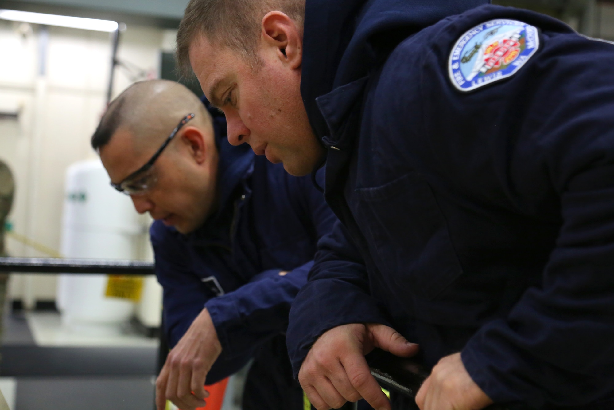 Emergency responders asses the scene as they arrive on scene of a simulated patient in a confined space rescue exercise at the Western Air Defense Sector Nov. 11, 2018, on Joint Base Lewis-McChord, Washington. The simulated patient fell into a generator pit after a major electrical malfunction. (U.S. Air National Guard photo by Master Sgt. Tim Chacon)