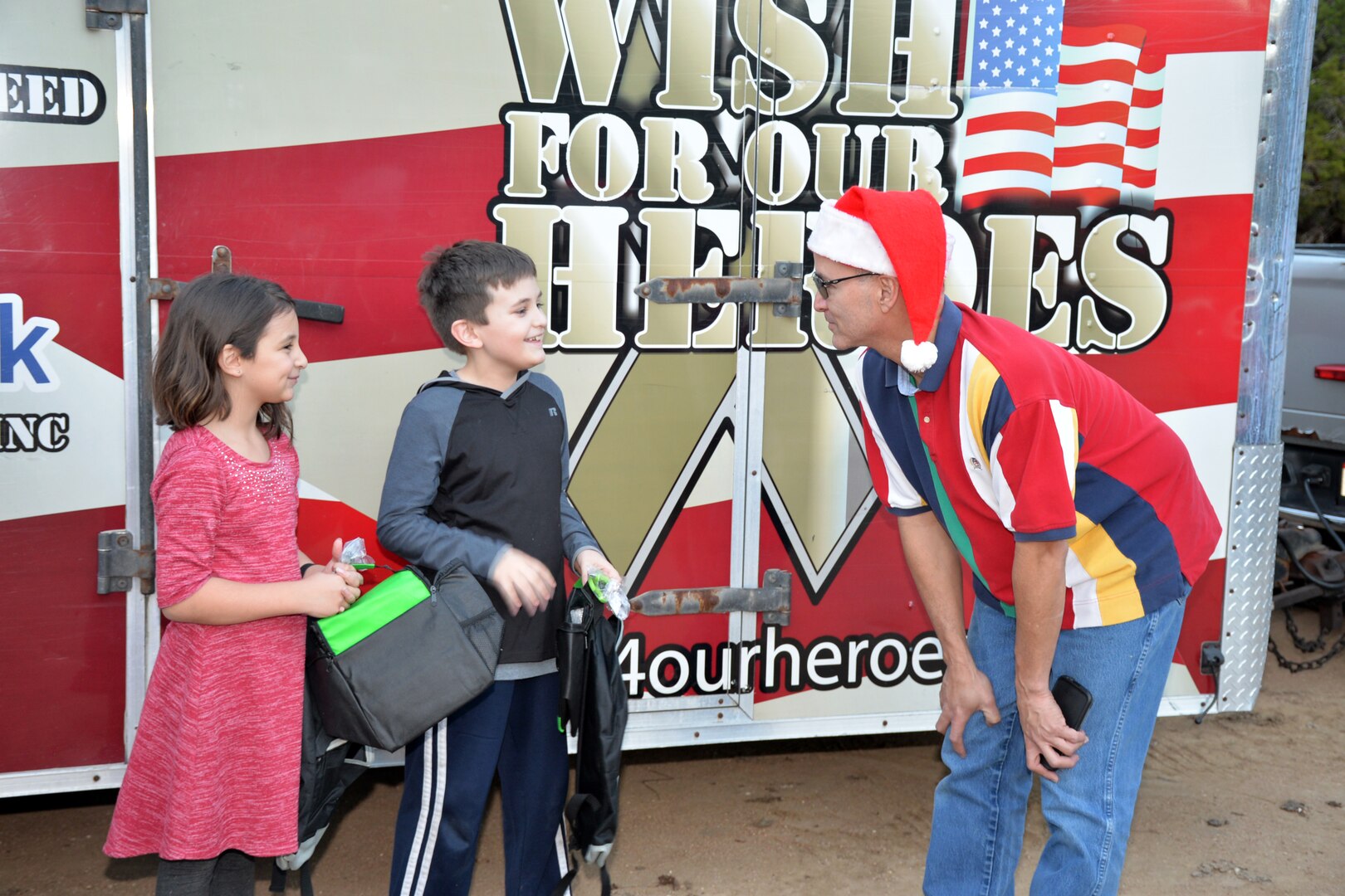 Master Sgt. Fernando Prendez, 433rd Airlift Wing Top-3 member, speaks with Senior Airman Krystal Donaghey’s children at her parents’ house following a gift presentation by WISH for OUR HEROES Dec. 17, 2018.
